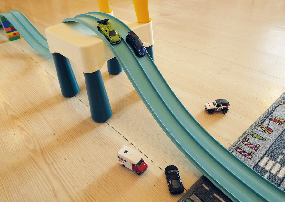 Piste Super Circuit deroulee sur un parquet avec plusieurs petites voitures